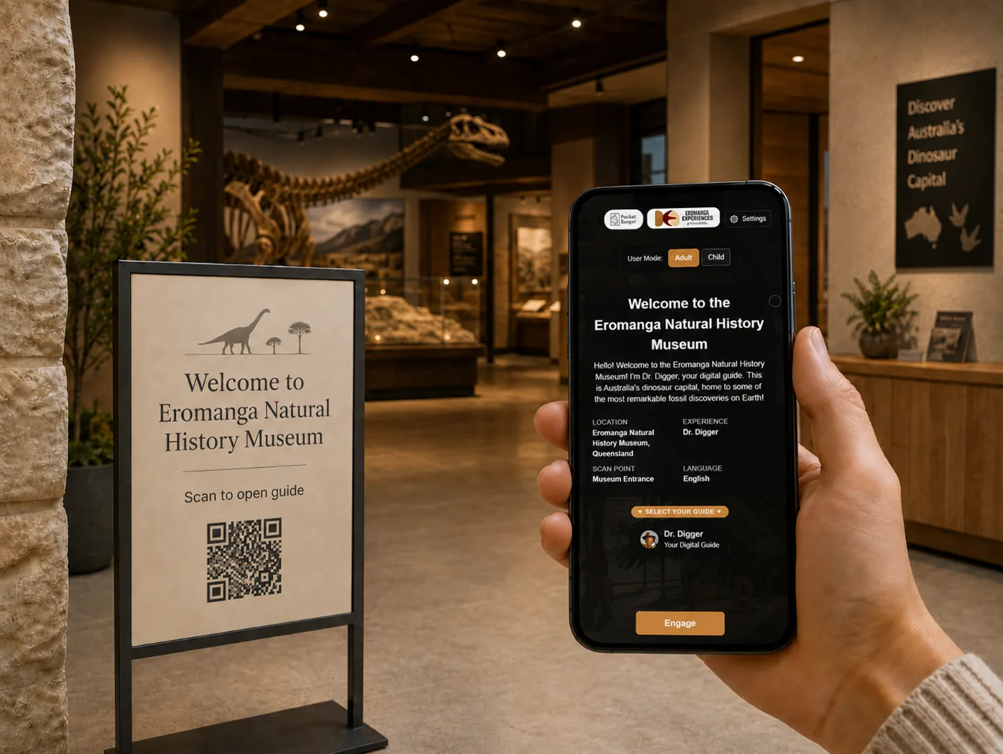 A visitor holds a phone showing the Eromanga guide beside a scan-to-open sign in a museum entry context.